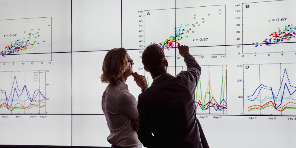 Two people looking at charts and graphs 