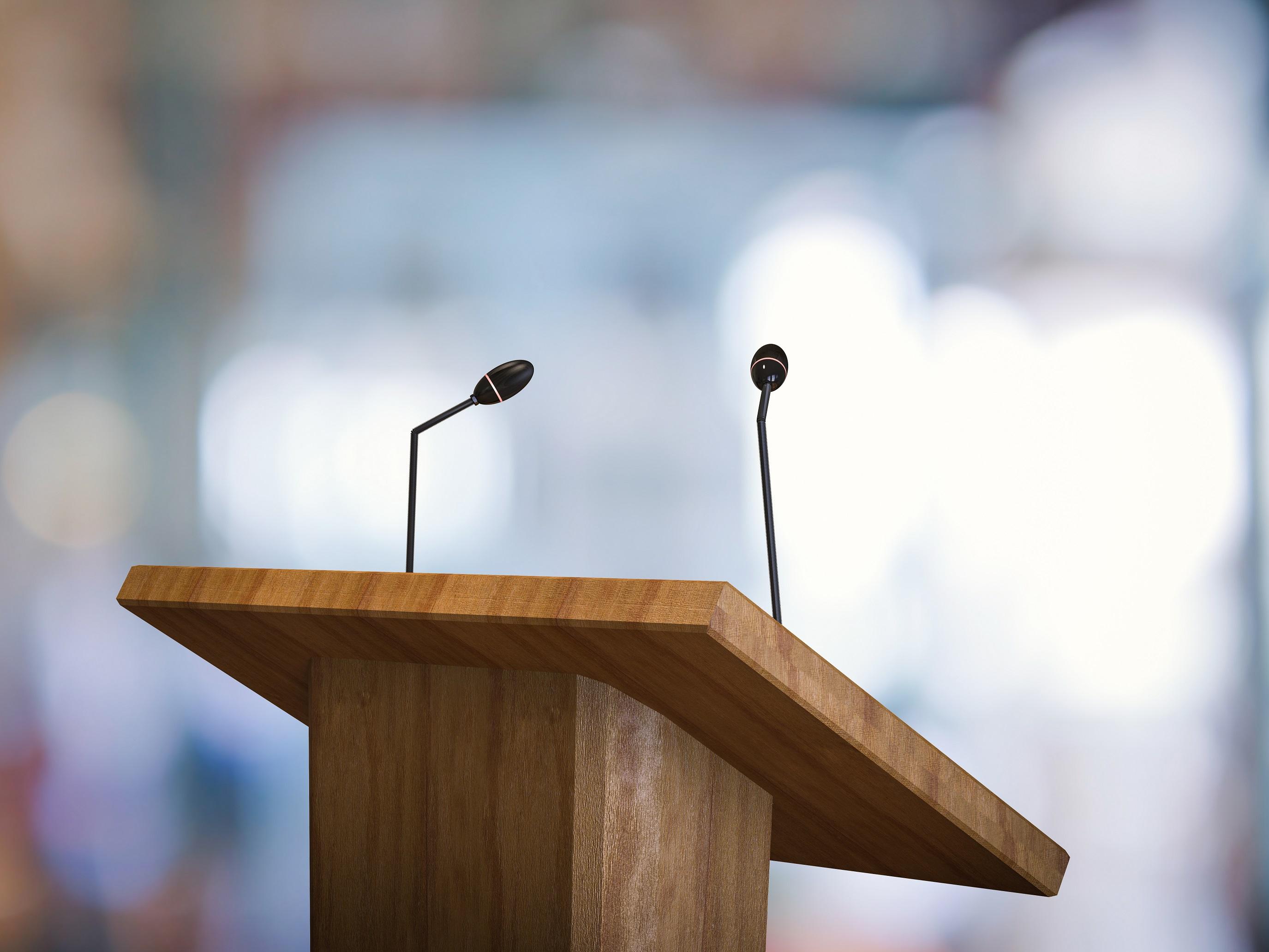 wooden podium with two microphones on it