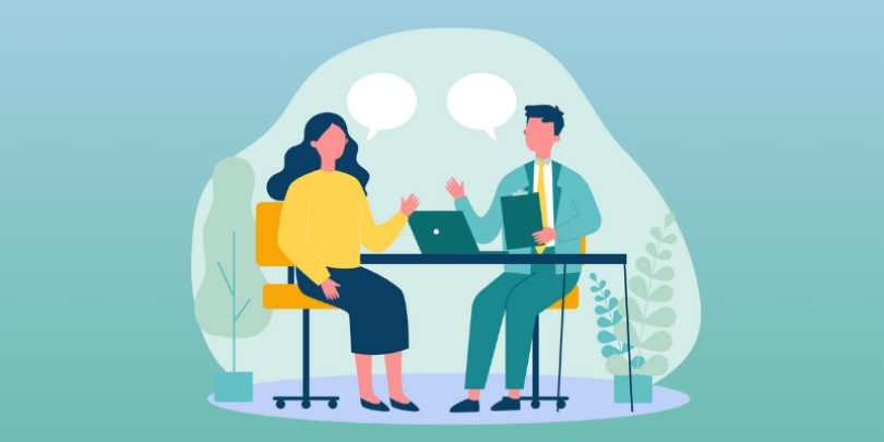 supervisor and employee discussing a project at desk