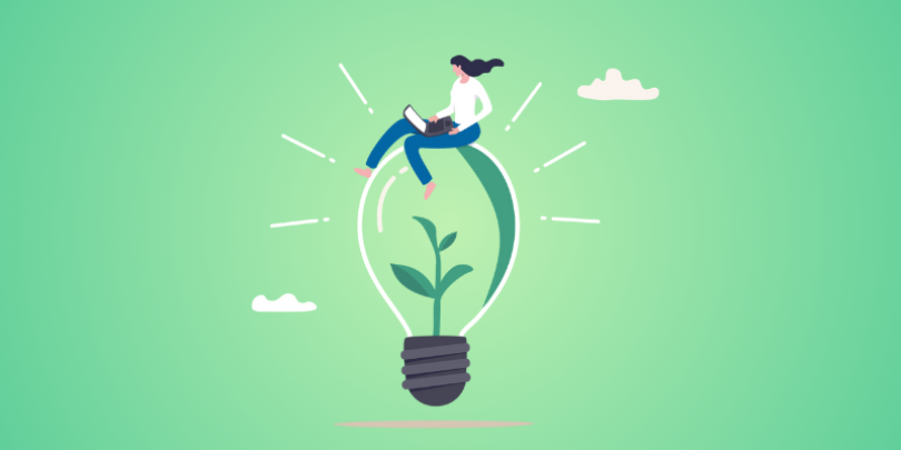 woman sitting on lightbulb using laptop