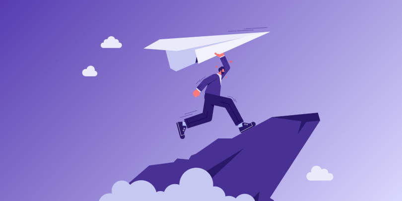 man holding paper airplane on a mountain