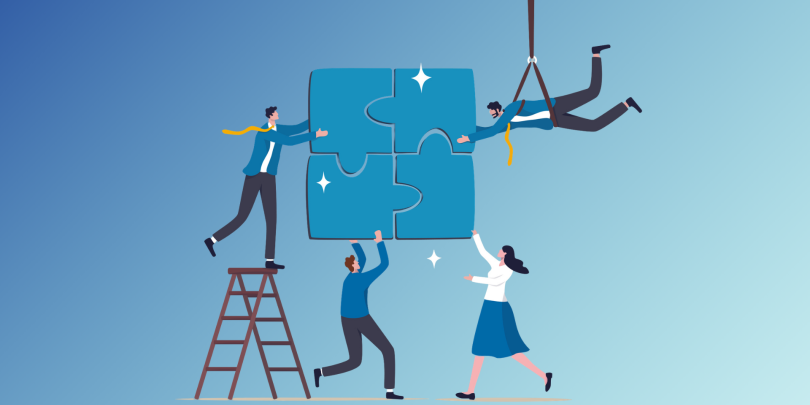 4 employees working together to complete a puzzle