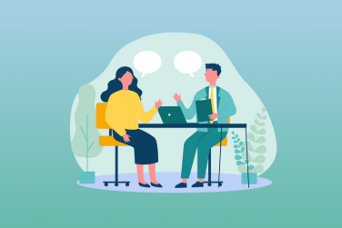 supervisor and employee discussing a project at desk