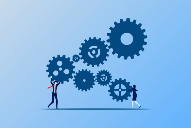 2 employees trying to prevent a bunch of connected gears from spinning