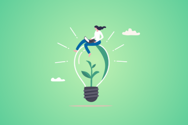 woman sitting on lightbulb using laptop