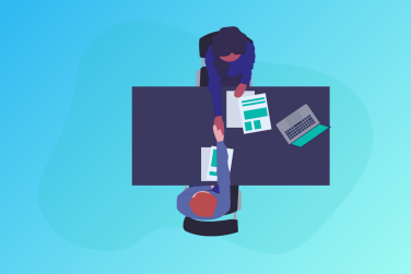 boss and employee shaking hands over a desk