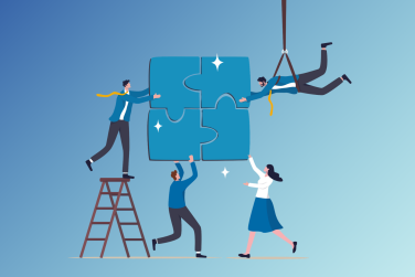 4 employees working together to complete a puzzle