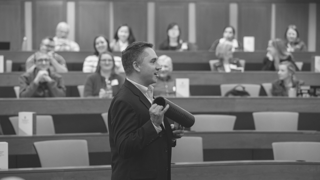 Man speaking in front of audience in lecture hall