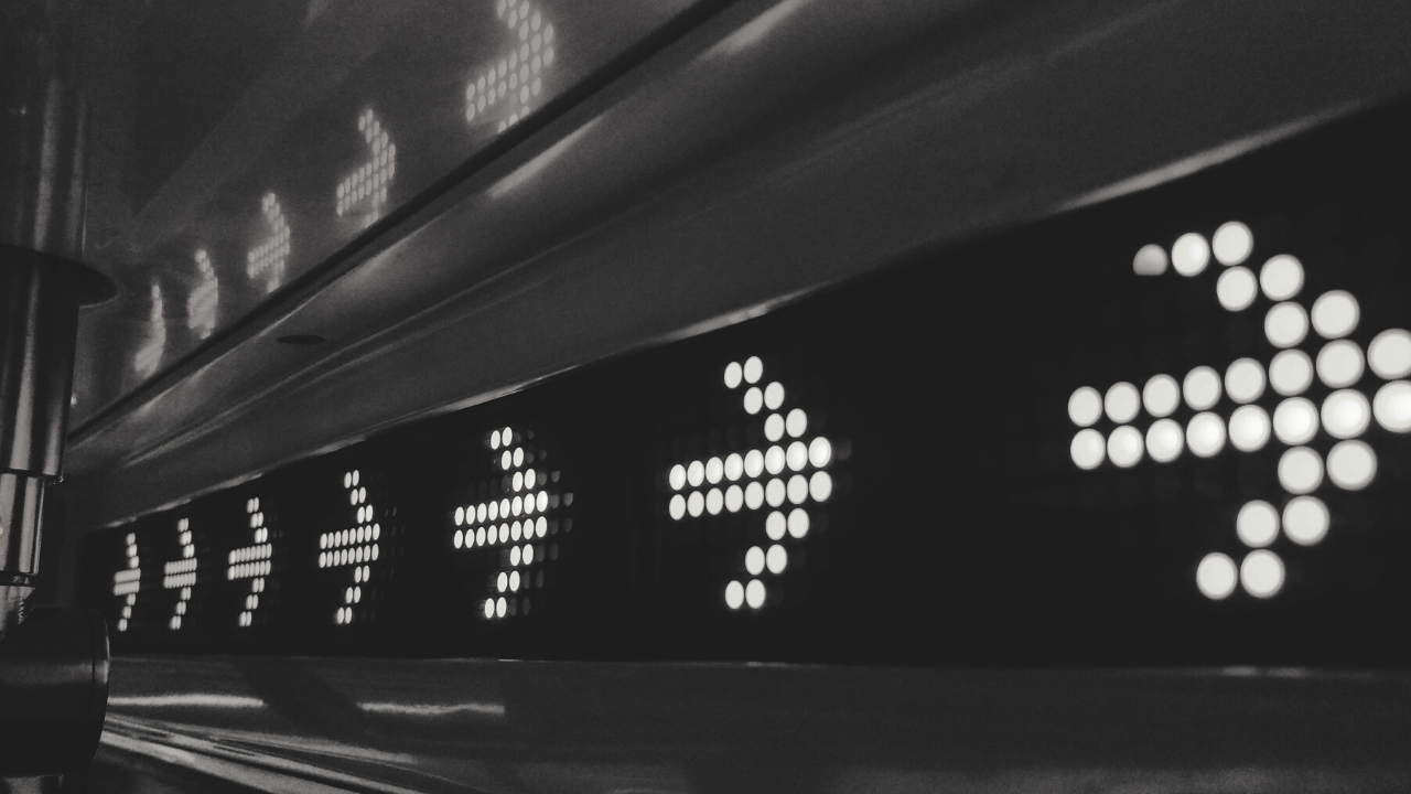 Black and white image of digital screen with arrows moving forward