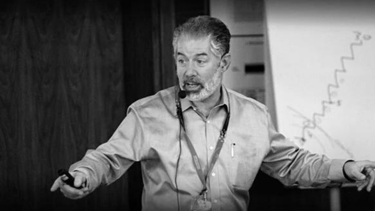 Black and white image of Mike Orzen on stage teaching