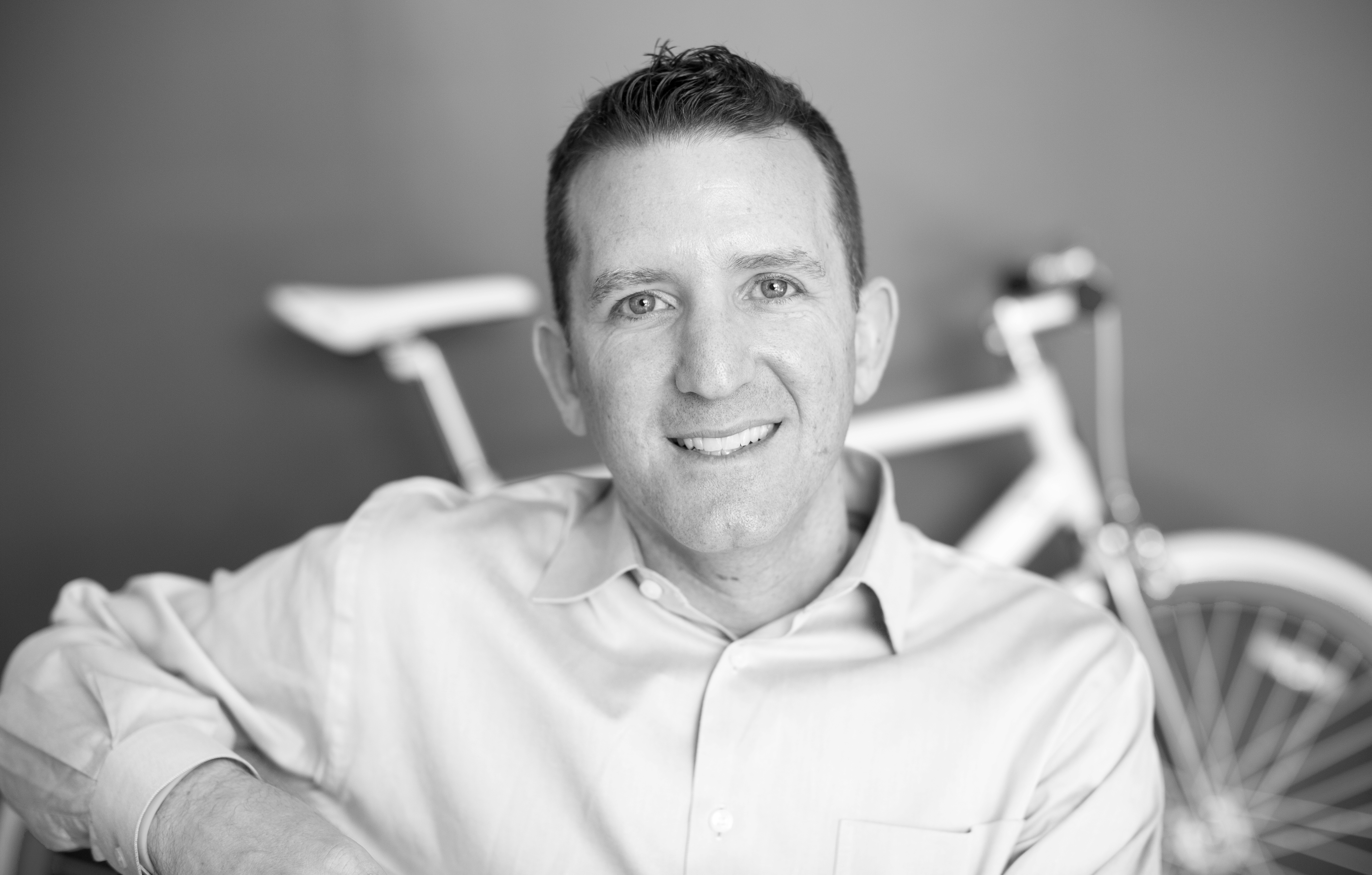 Doug Ulman sitting with bicycle in background