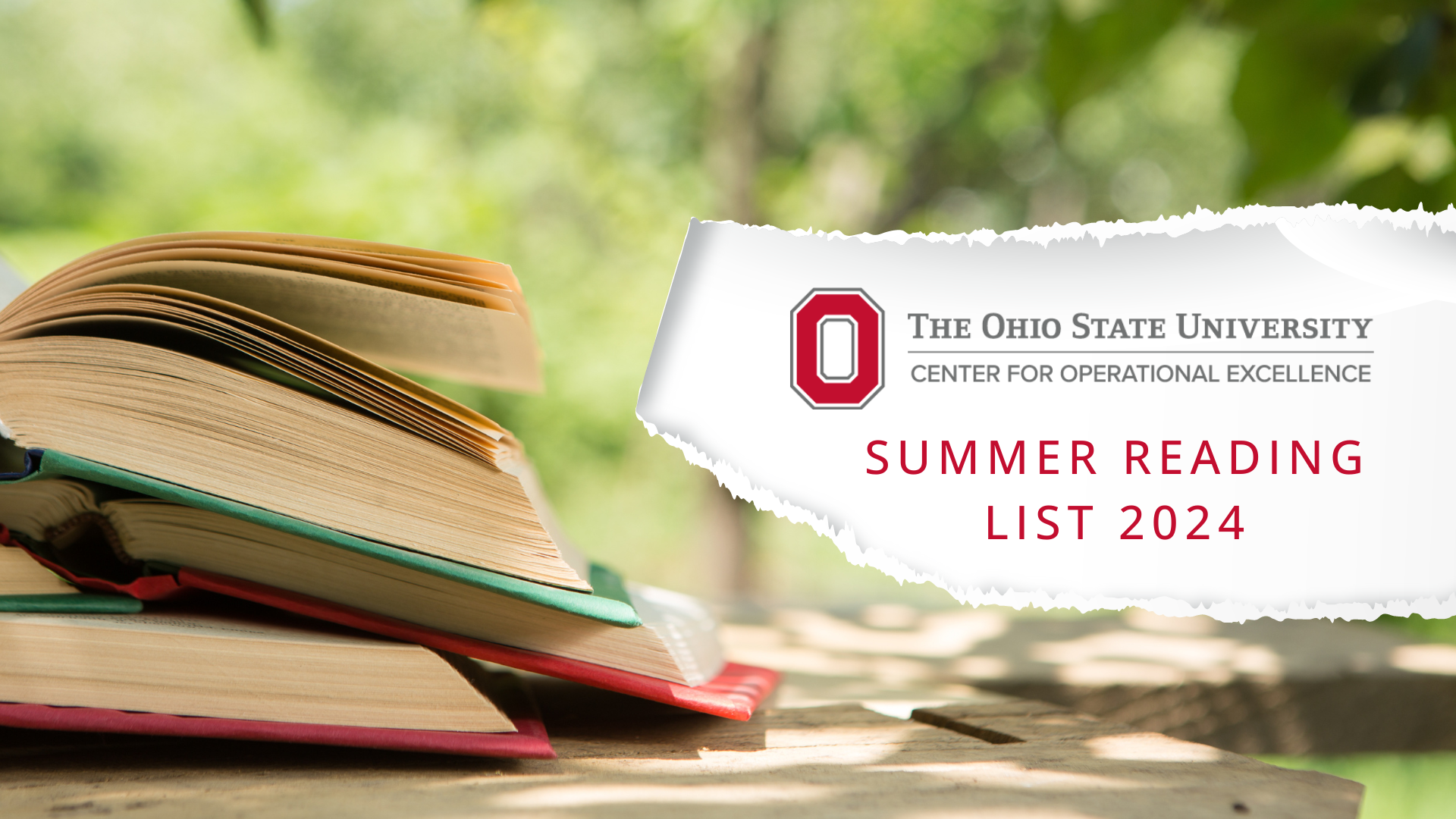 Stack of books open on picnic table on summer day