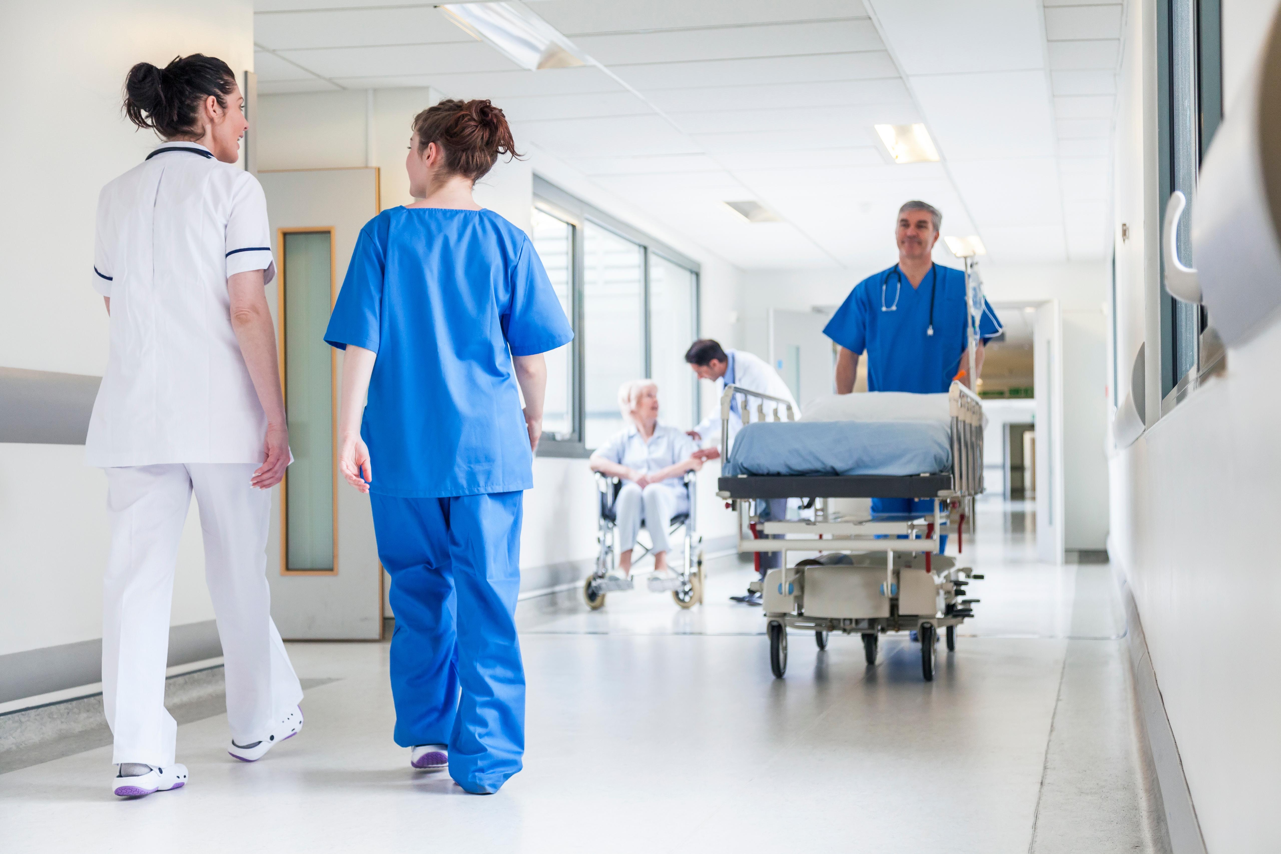 Healthcare workers walking through a hospital corridor