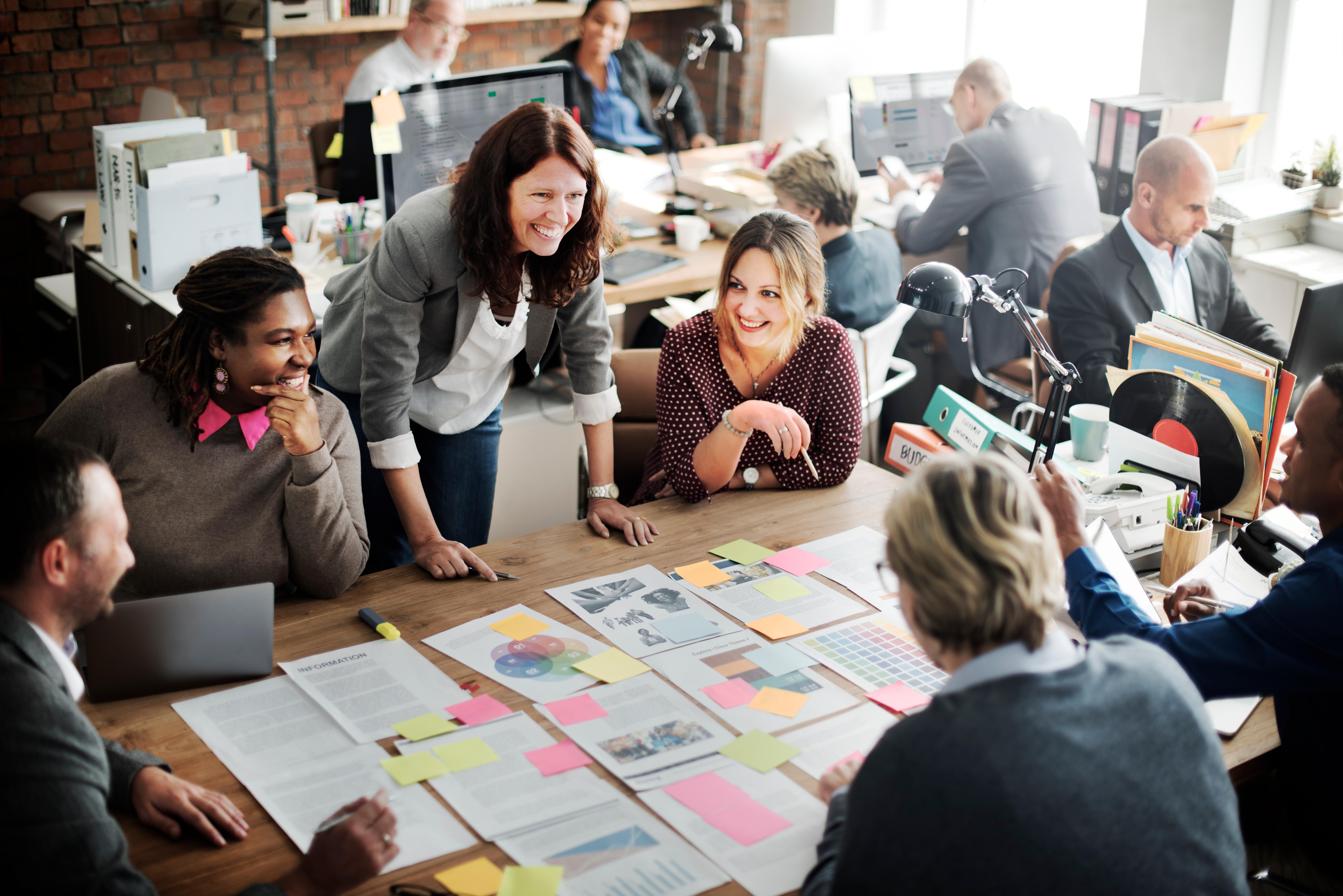 Team seated around table covered in post-it notes