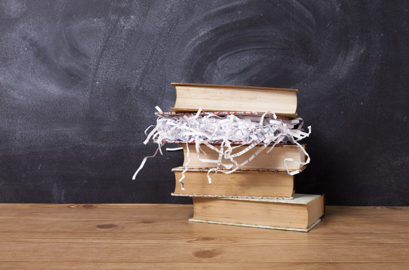 Stack of books with one book full of paper shreds