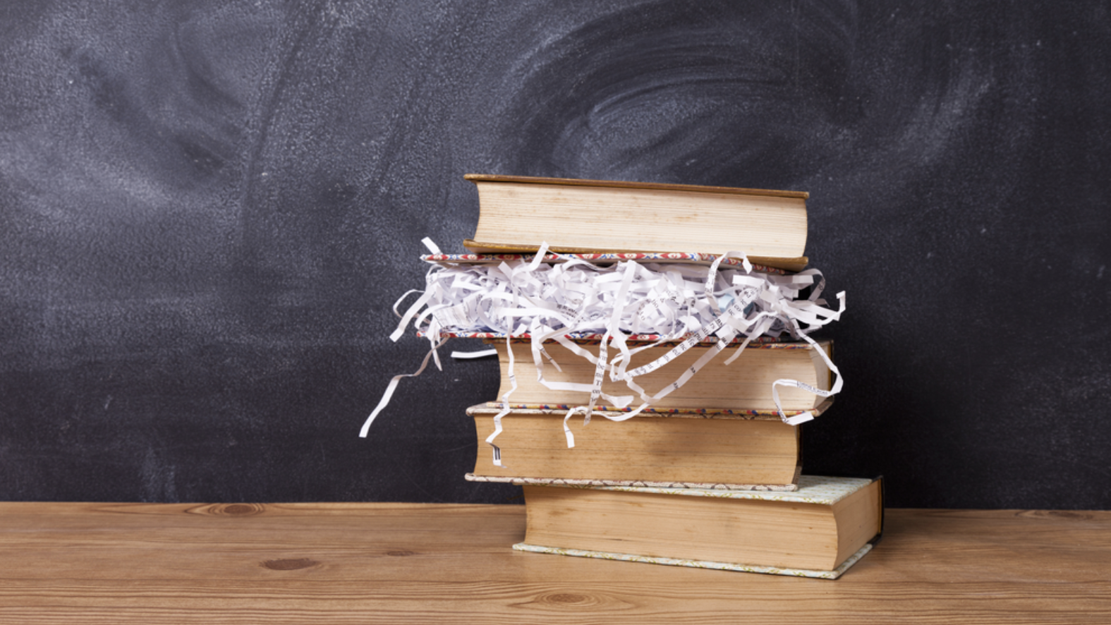 Stack of books with one book full of paper shreds