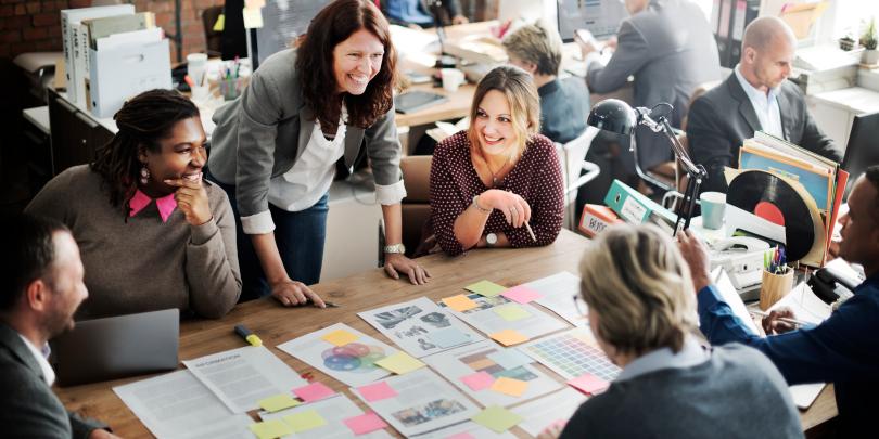 Team seated around table covered in post-it notes