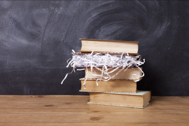 Stack of books with one book full of paper shreds