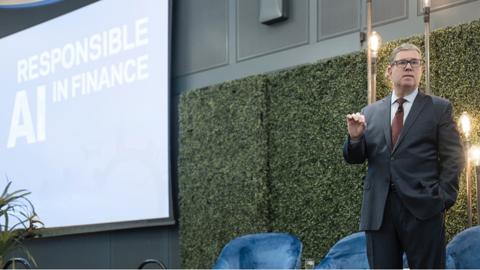 James Kavanaugh giving a presentation on a stage next to a screen with the words Responsible AI in Finance.