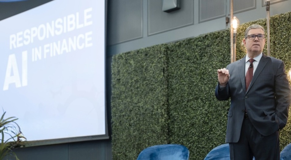 James Kavanaugh in a suit in tie standing on a stage next to a screen that reads Responsible AI in Finance.