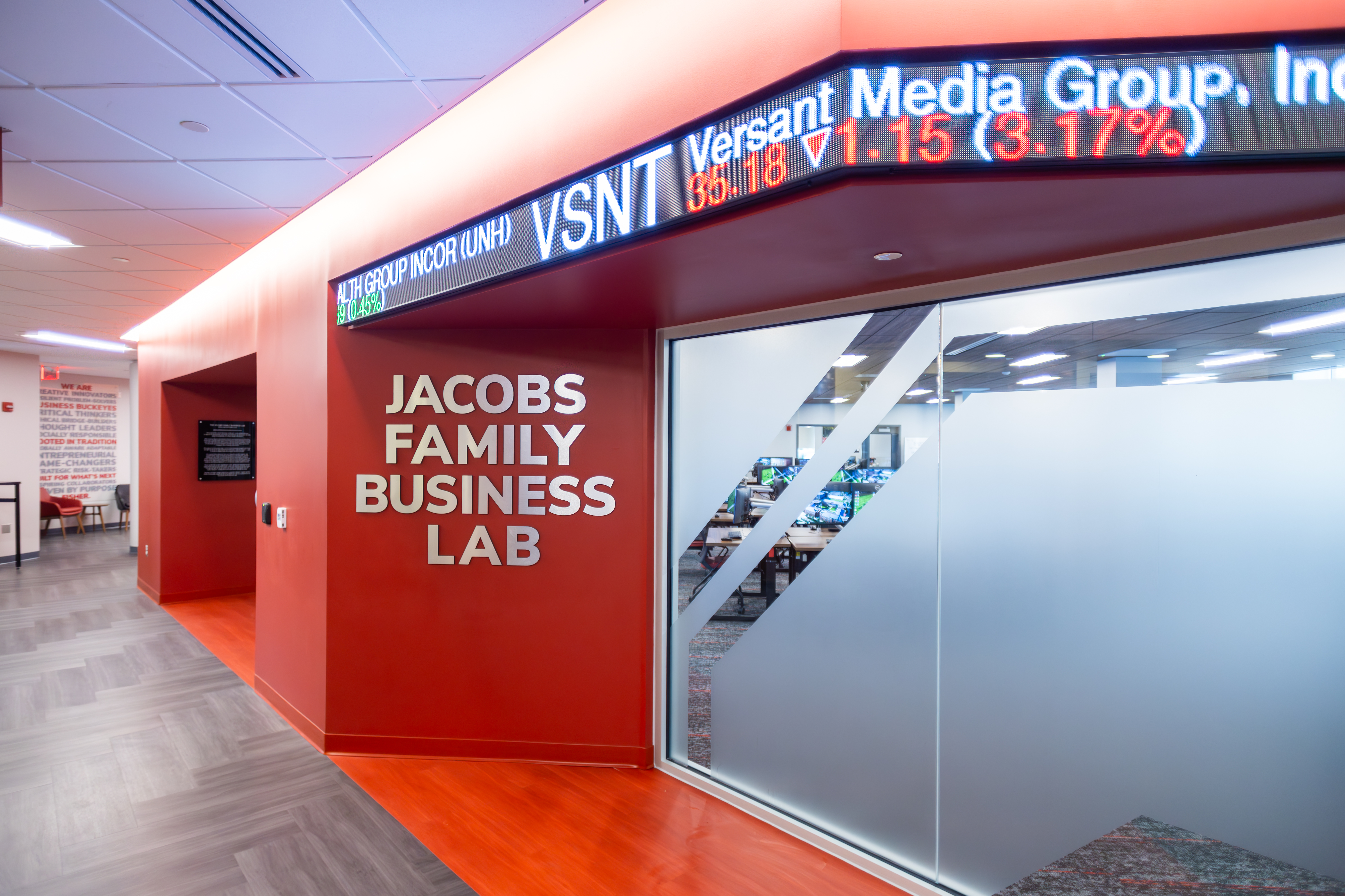 The exterior of the Jacobs Family Business Lab including a digital stock ticker and frosted glass walls.