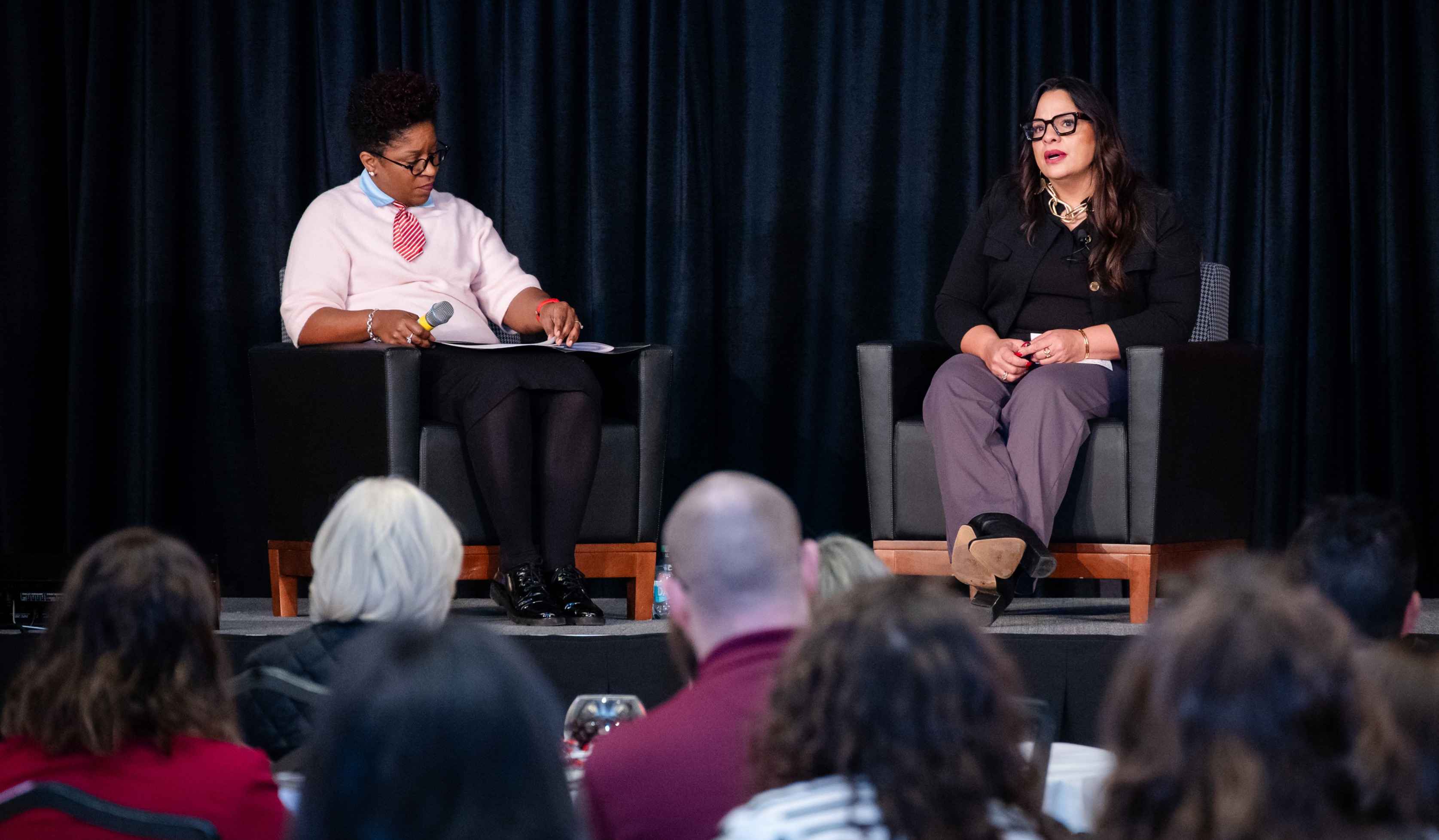 Elizabeth Martinez, right, is seated in a chair on a stage in the Ohio Union next to Cynthia Turner