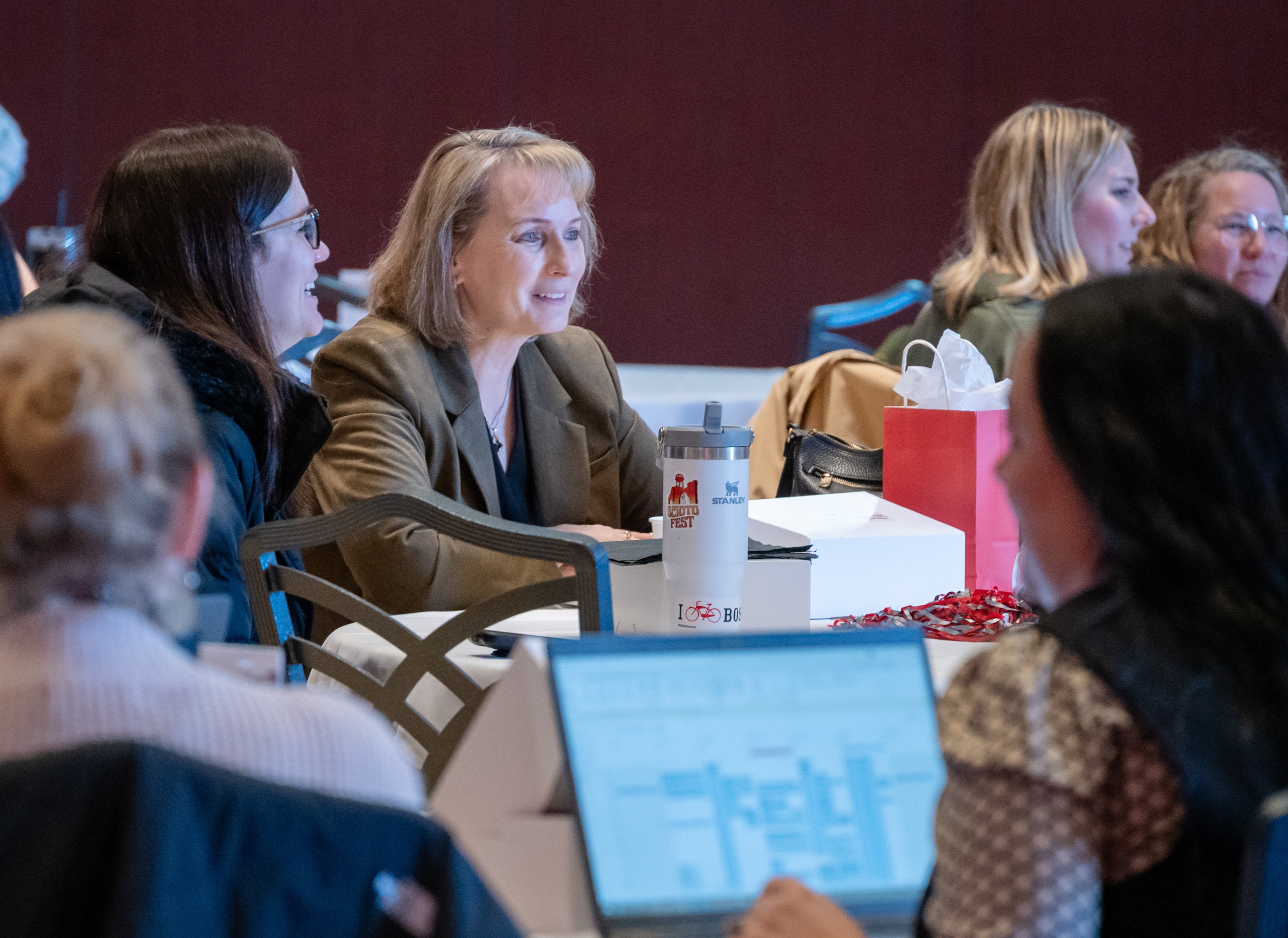Jeri Ballard is seated at a table amid a group of people at the Converge conference in the Ohio Union.