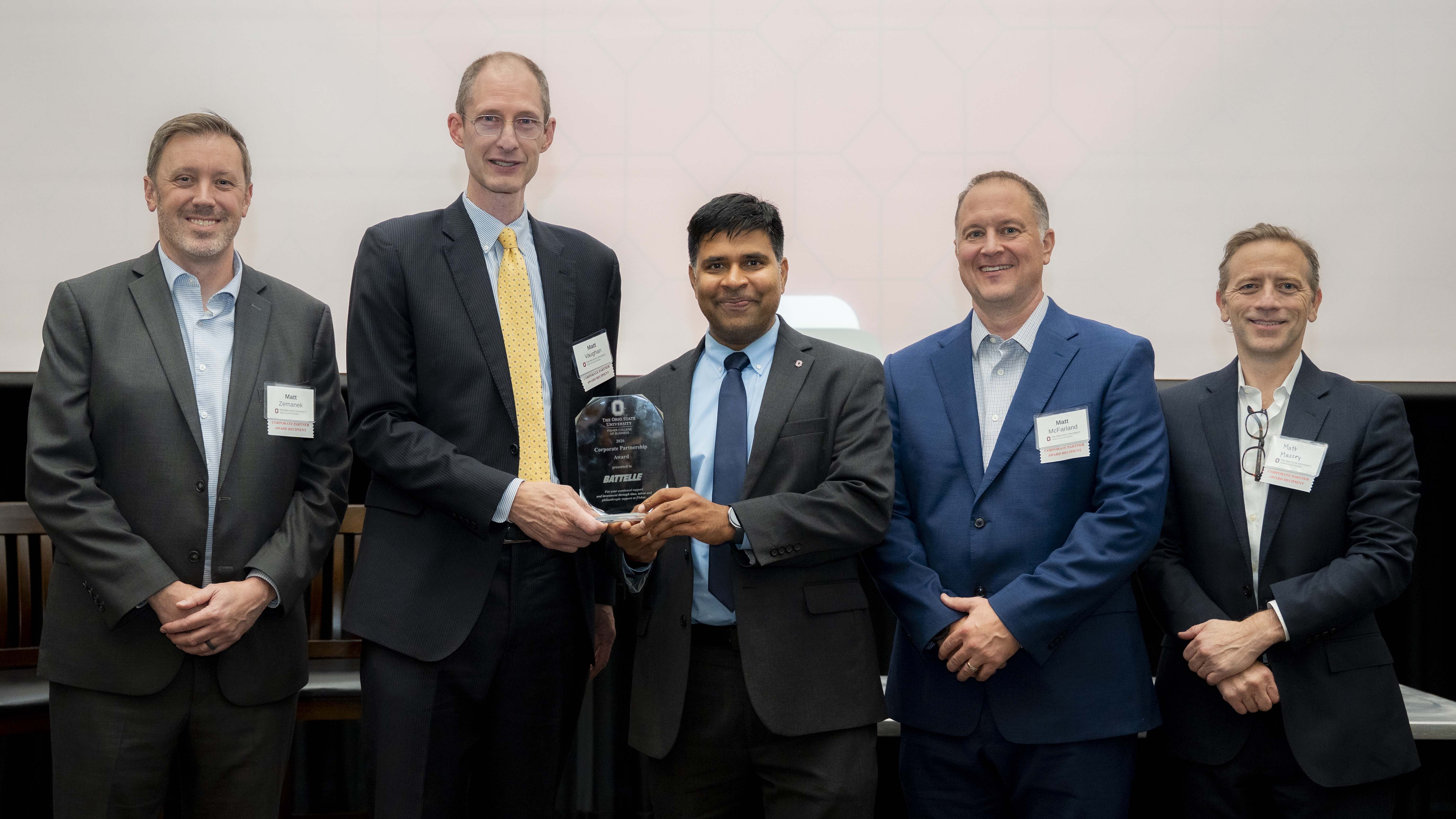 Interim Dean Aravind Chandrasekaran stands in the center of four men representing Battelle with AC and one of the men holding a glass award.
