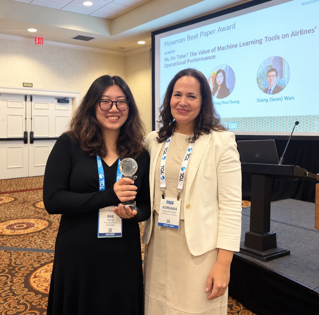 Rang Gong poses with her research award with a conference presenter.
