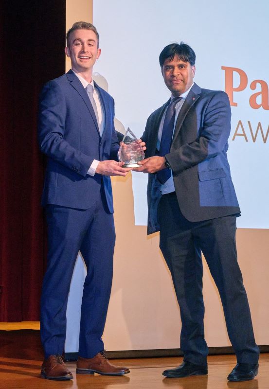 Fisher's Dean AC awards Caleb Wooddell her Pace Setters Award on stage with a Pace Setters screen in background.
