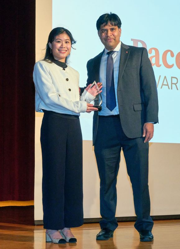 Dean AC awarding Cara Santos her Pace Setters Award with Pace Setters screen in background