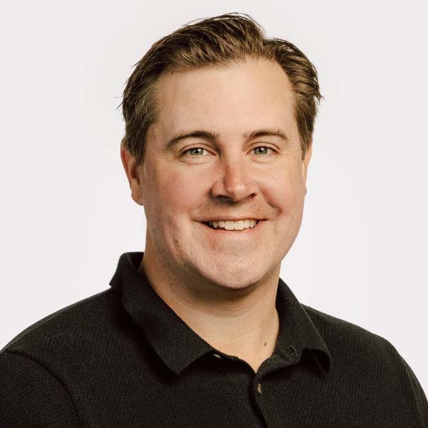 Headshot of Craig Baldwin in a black polo shirt.