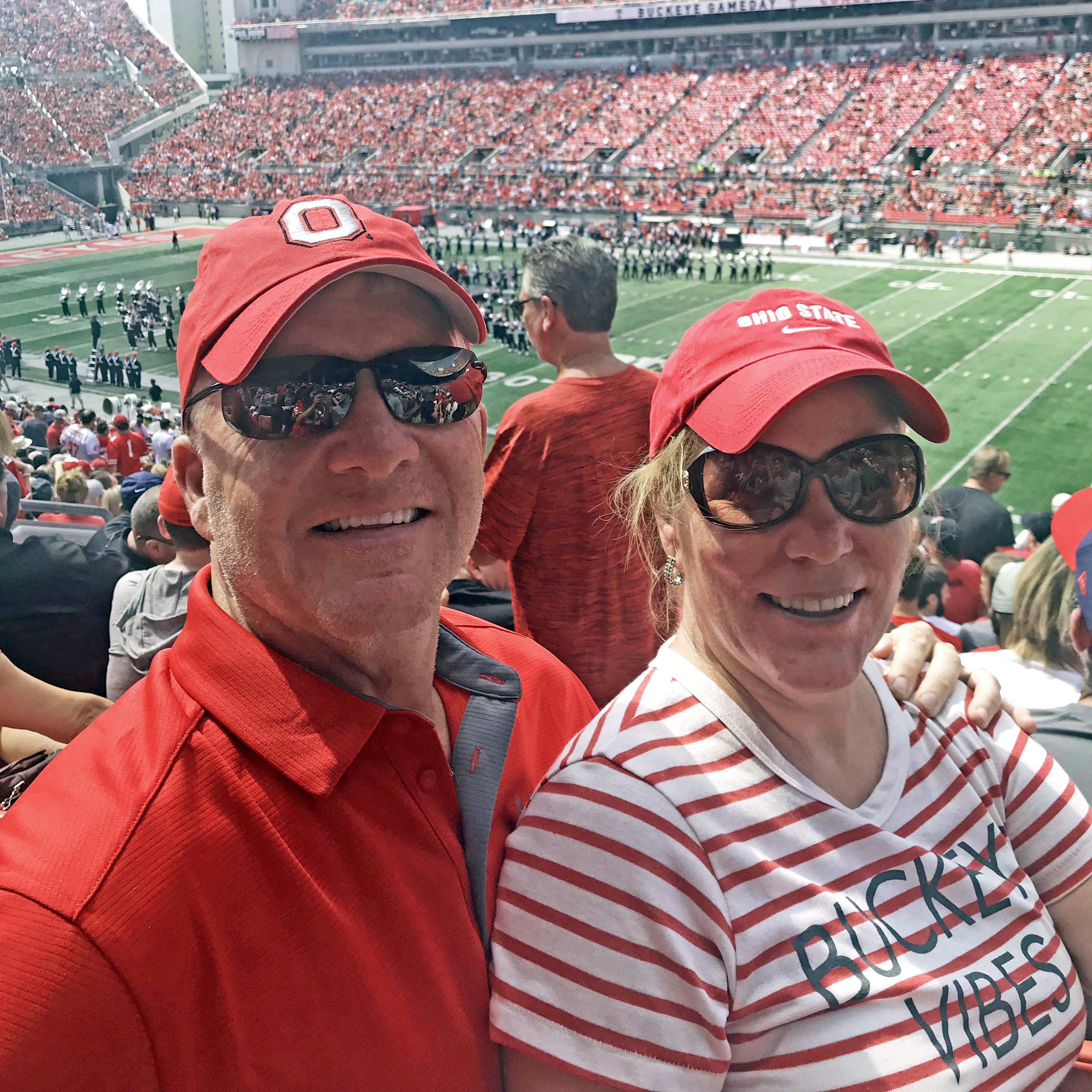 Dave and Brenda Jacobs are dressed in Ohio State shirts and hats seated inside the 'Shoe during a game.