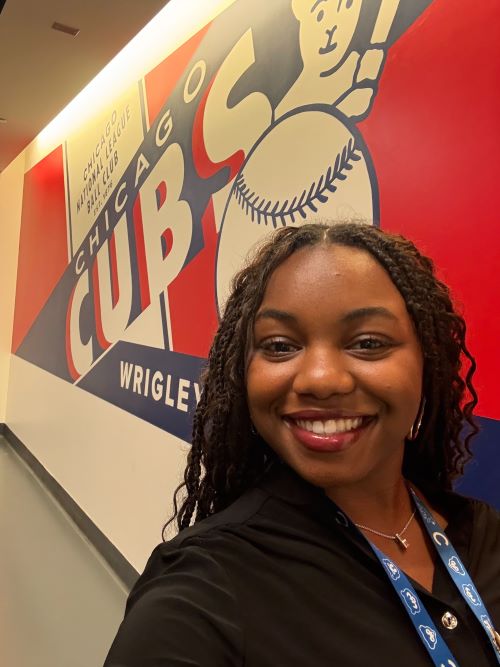 Elisabeth Christina in front of red, white and blue Chicago Cubs sign inside the stadium