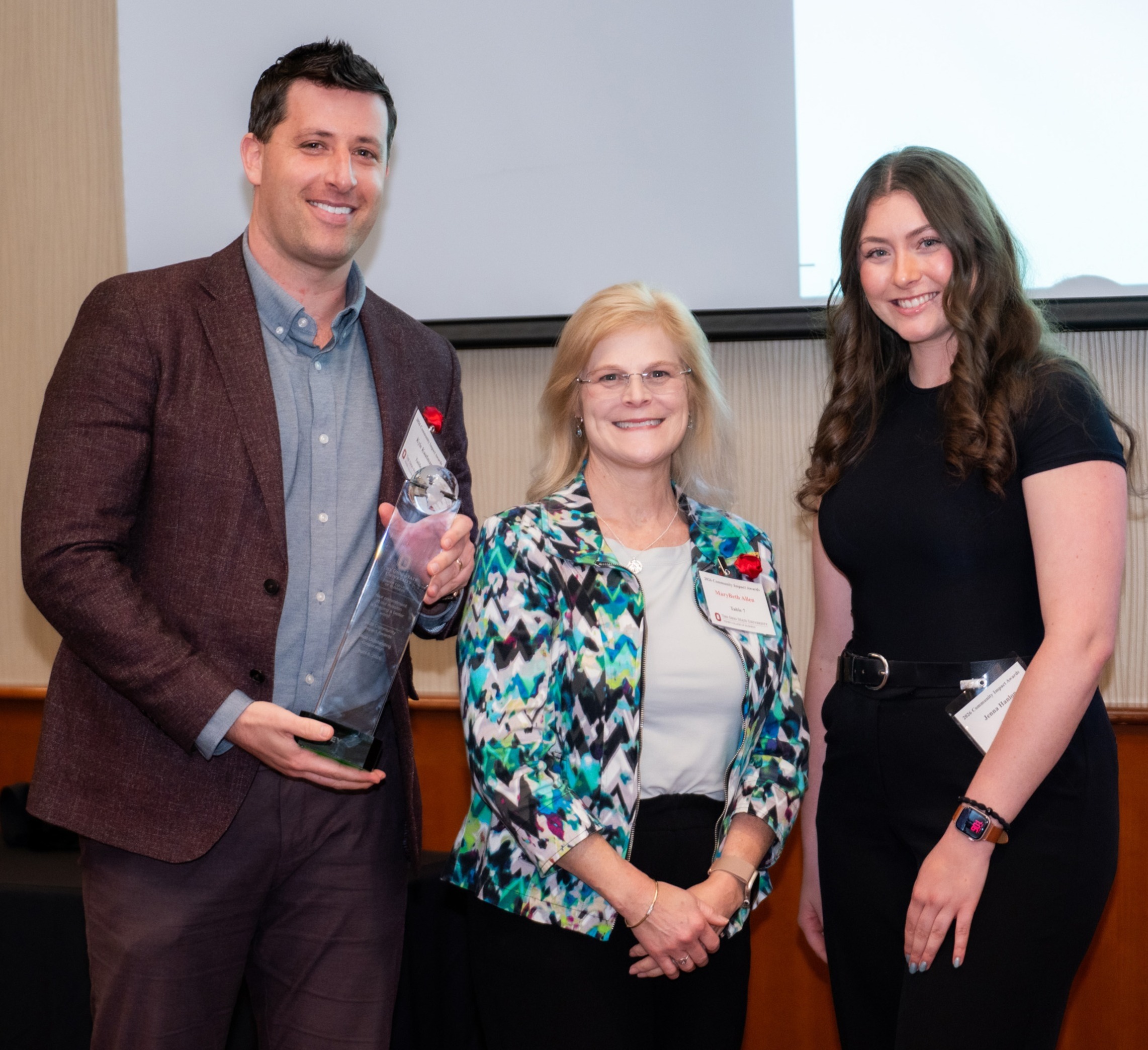 EY representatives Kyle Kaufman, left, and MaryBeth Allen, center, pose with student Jenna Hanlon, vice president of Women in Business.