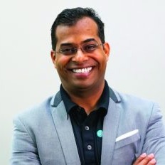 Portrait of Venkatesh Ganapathy wearing a light blue suit and dark shirt.