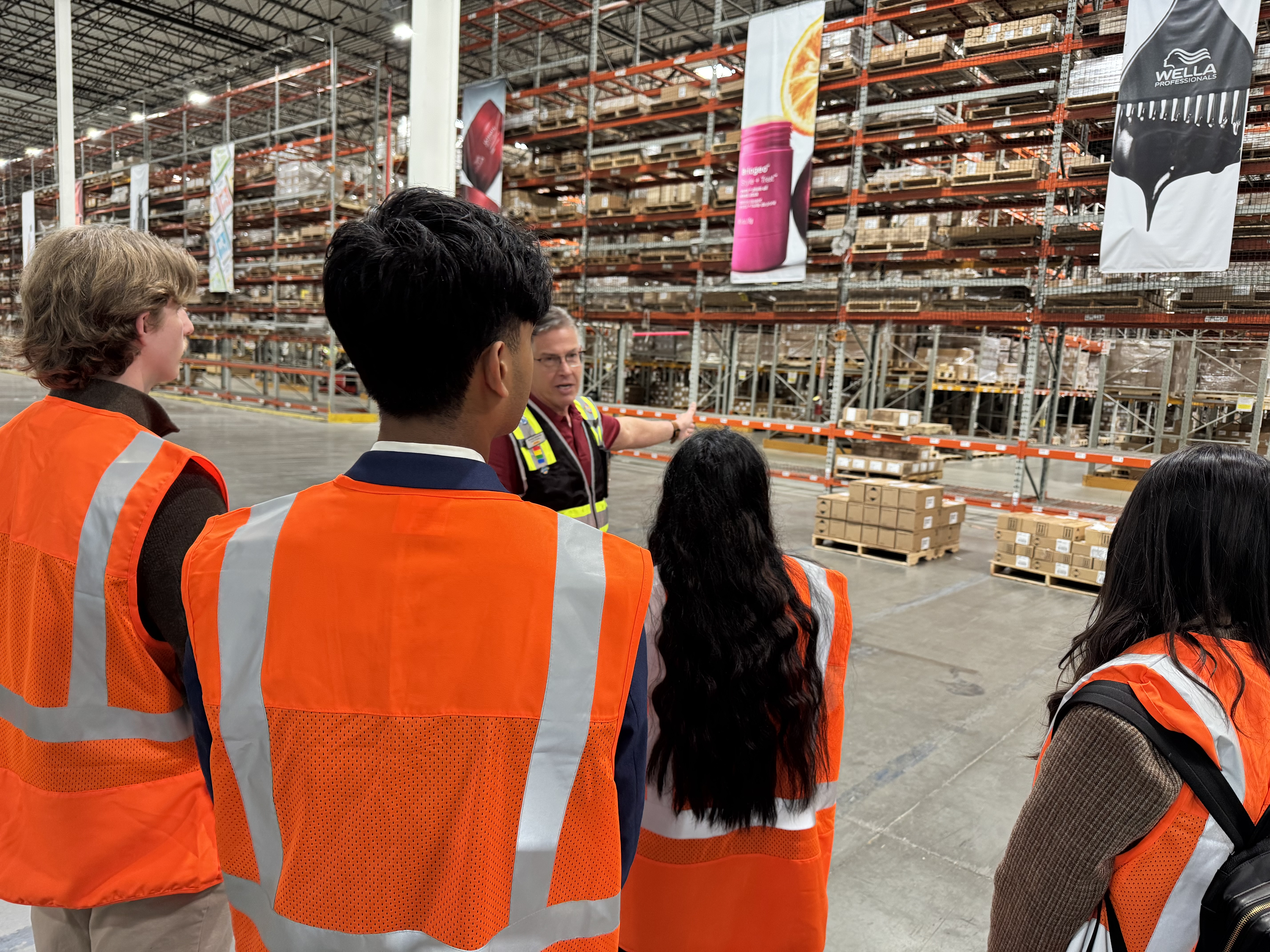 Students in safety gear inside a warehouse.