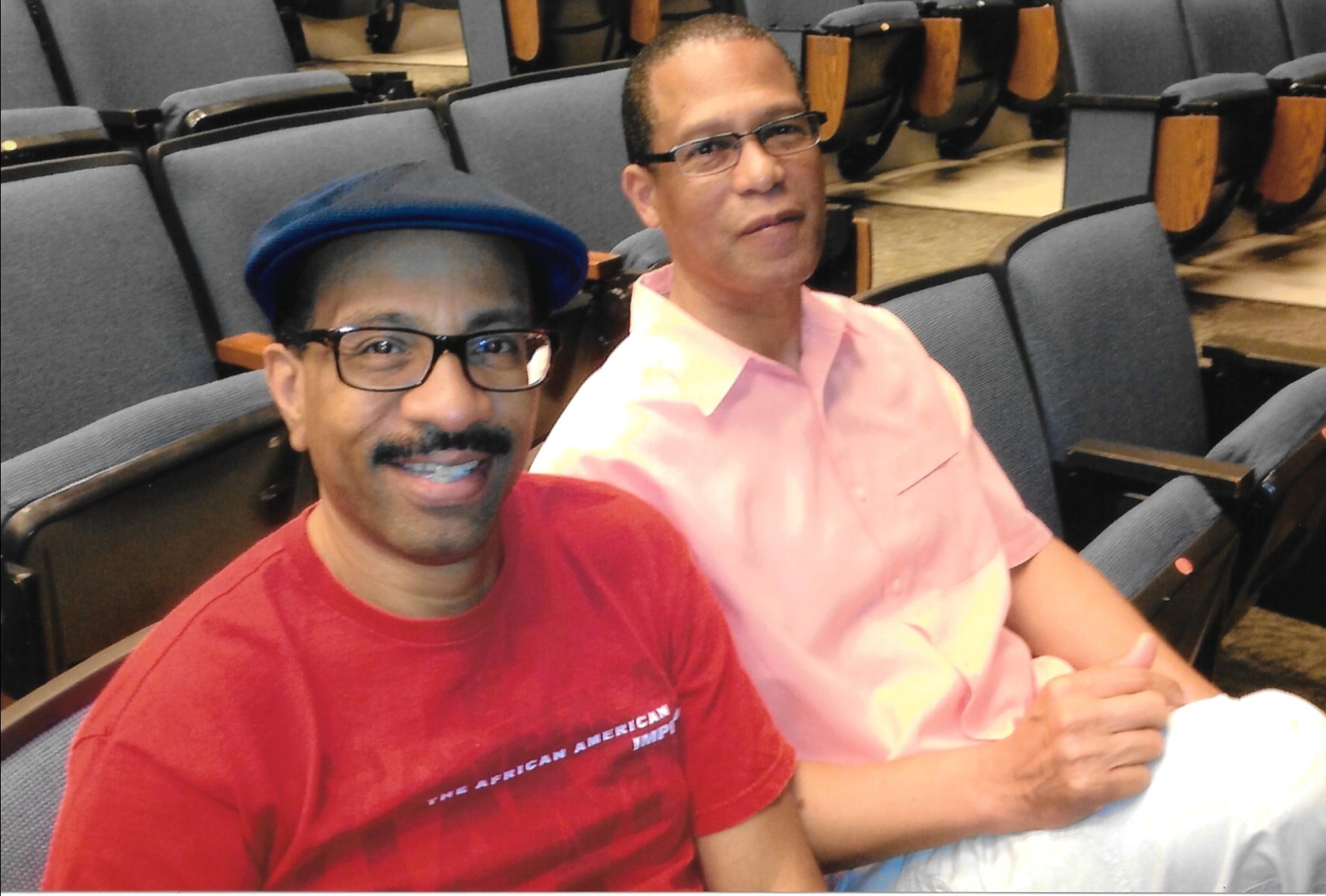 Leroy McKinney, left, and Dwight Smith are sitting in next to each other in auditorium seats.