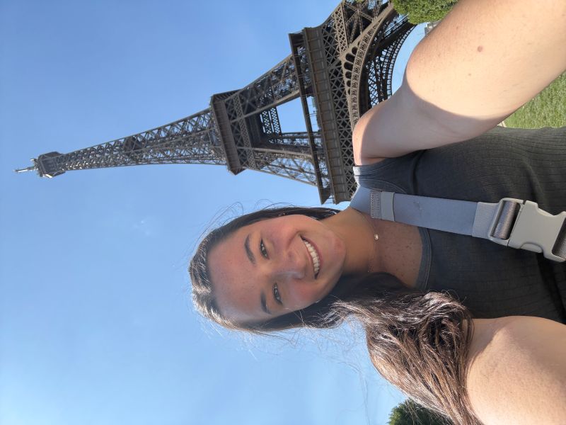 Woman taking a selfie in front of the Eiffel Tower in Paris