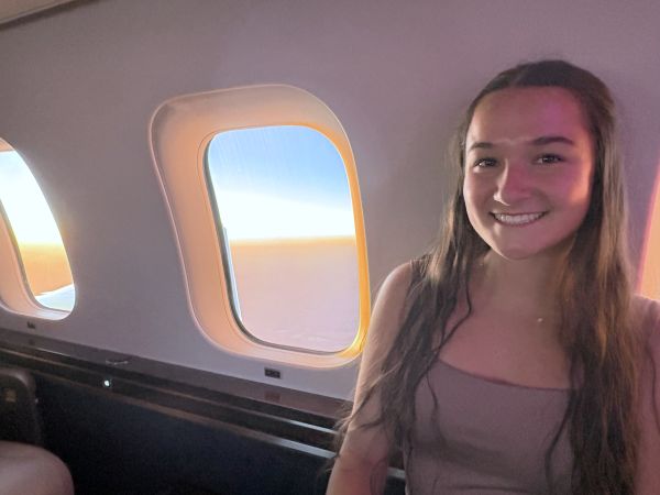 Lexy Payne sitting on a private jet, leaning up against windows