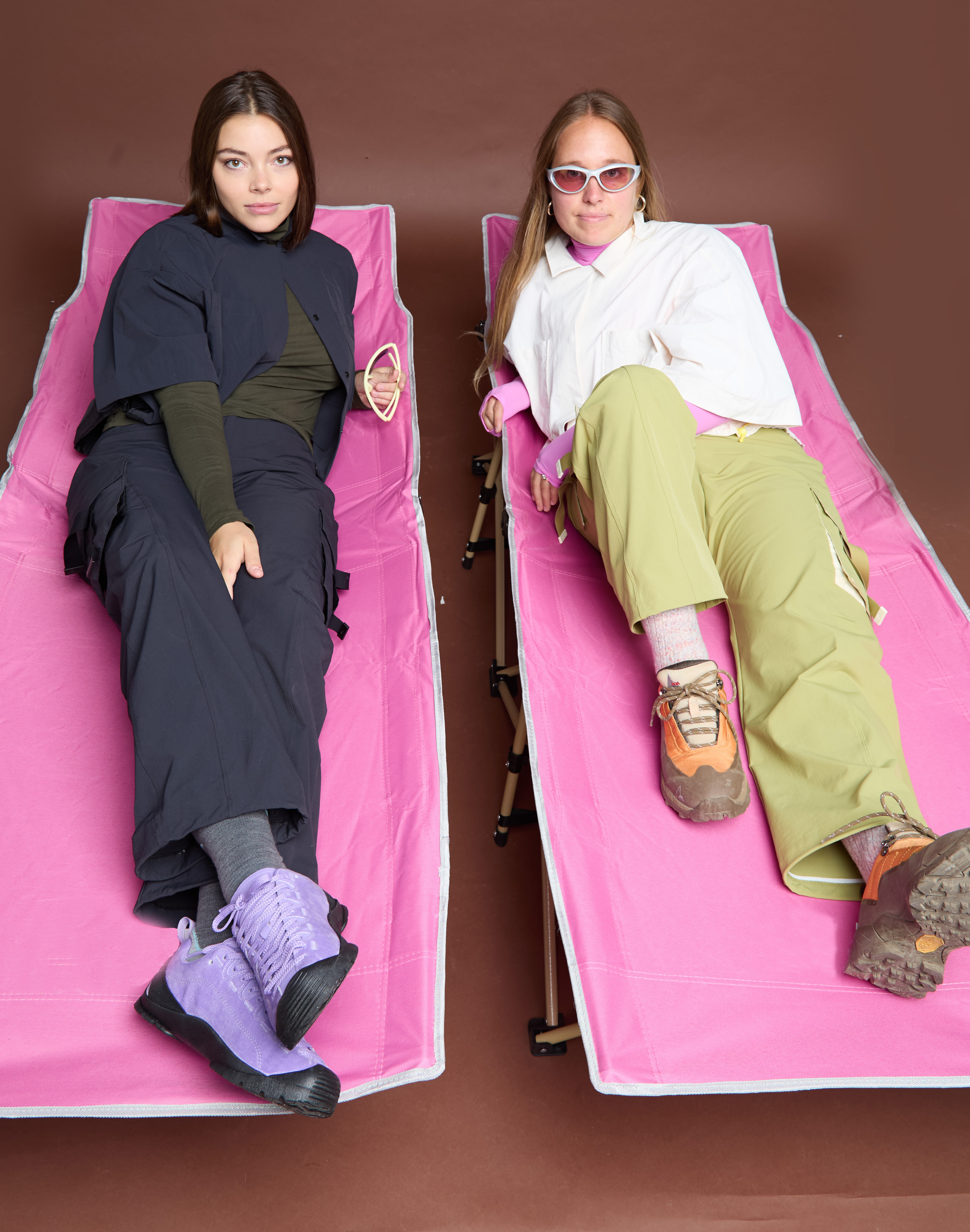 Madeline Hilson and Valentina Thompson pose on pink cots wearing SENIQ hike apparel.