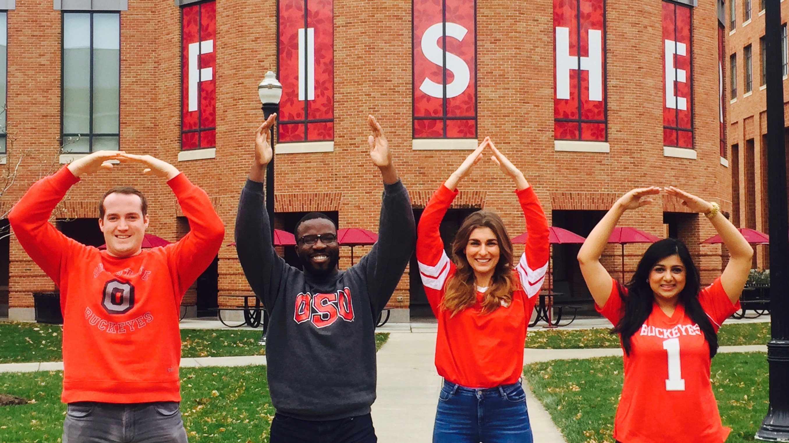 Neethi, far right, and three classmates all dressed in their Buckeye gear and spelling O-H-I-O with their arms.