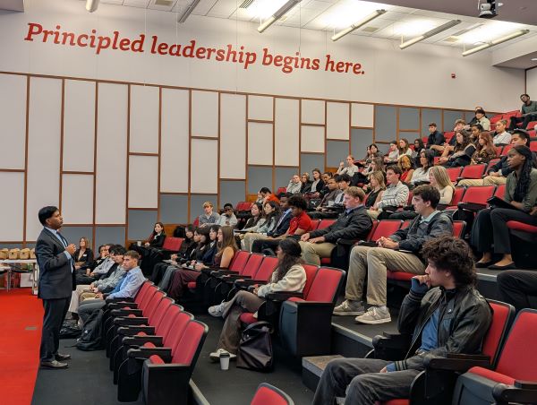 Dean AC in front of large classroom addressing students