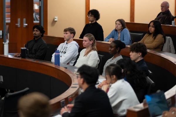 Students sitting in an arched classroom listening to James Kavanaugh