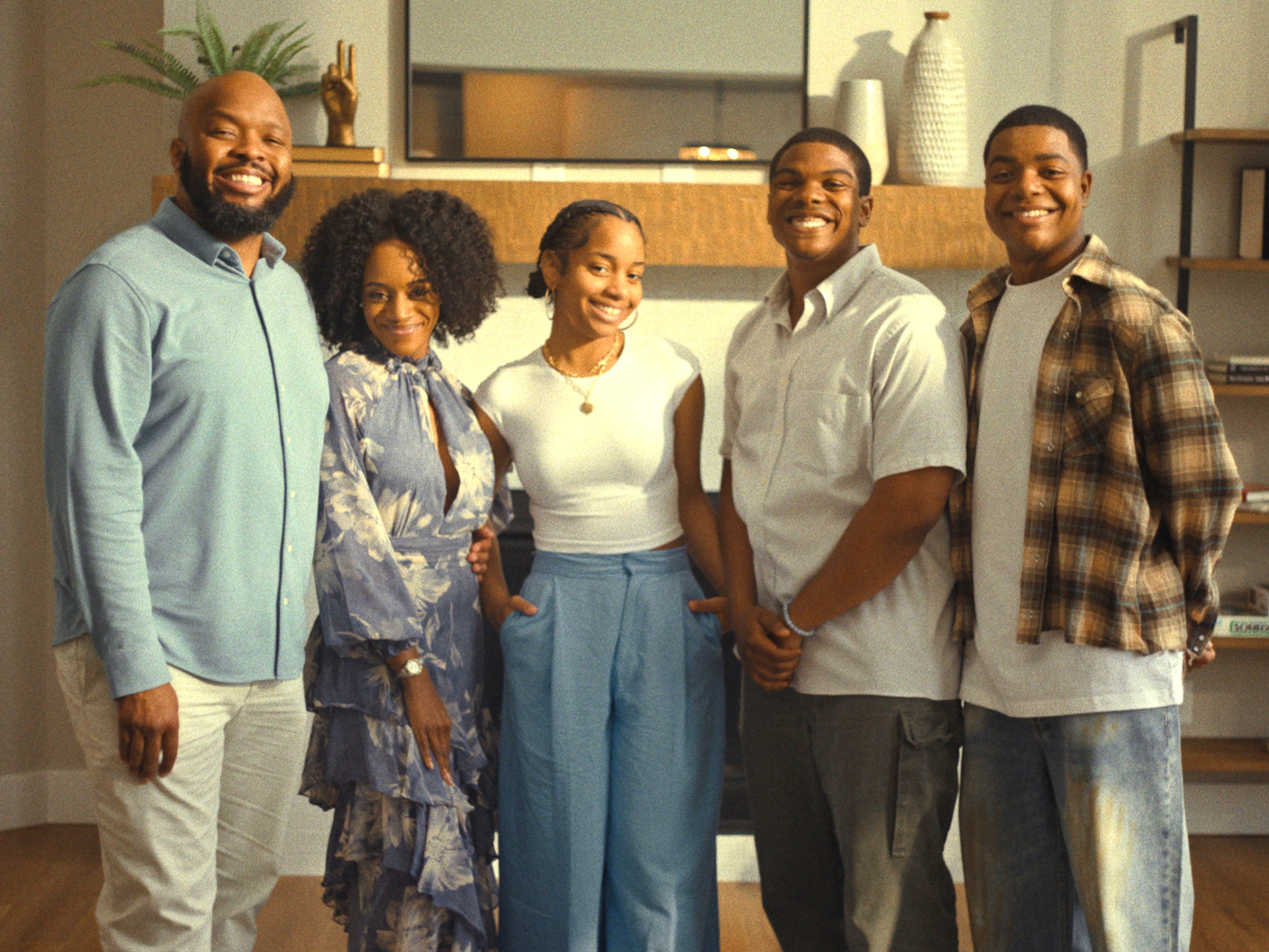 Five members of the FreeLance cast standing in front of a mantle in a house.