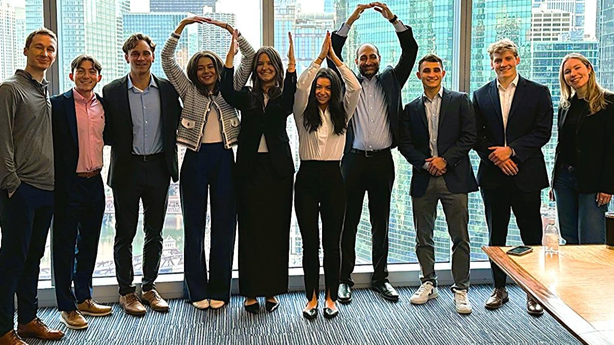 Leaders of the Fisher Real Estate Society and Alumni Board mentor Arun Singh, fourth from right, pose for a photo in a Chicago office building.