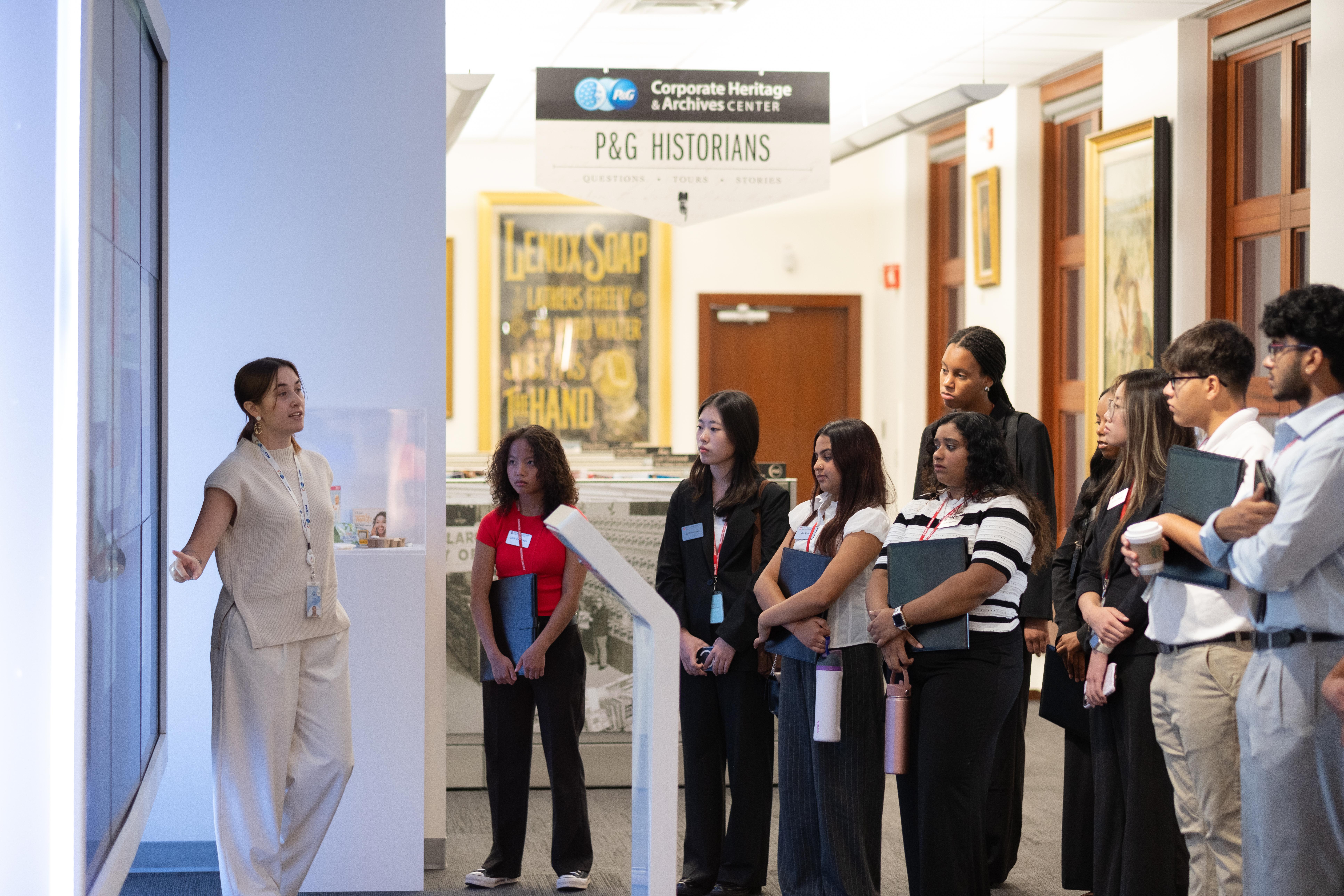 Group of students listening to P&G staff member explain exhibit at the Heritage Center
