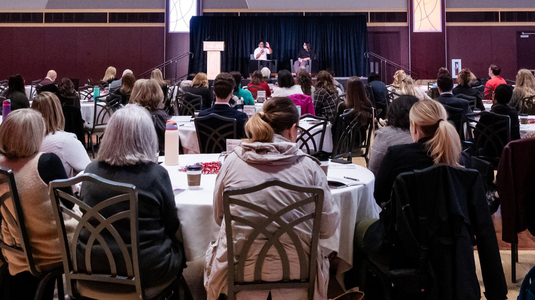 People seated around round tables in the Ohio Union ballroom.