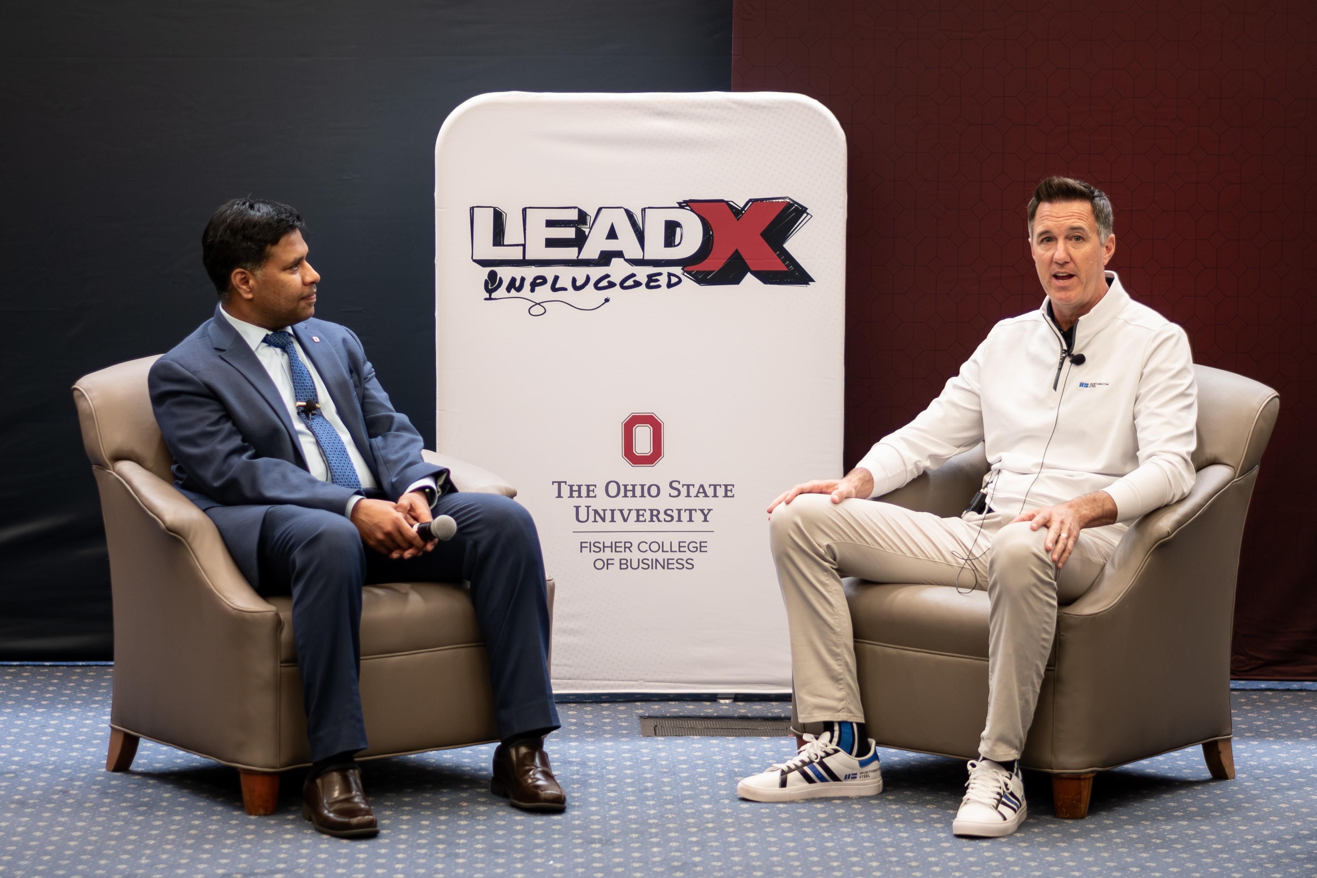 Dean Aravind Chandrasekaran and Geoff Gilmore sitting opposite each other with LeadX sign in background