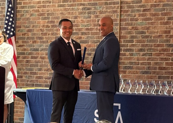 Levi Duncan shakes hands with a man after receiving an award at the Ohio Small Business Week and Lender Awards.